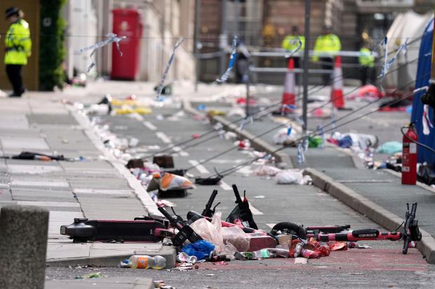 Scooters lie on the site where a 53-year-old British man plowed a minivan into a crowd of Liverpool soccer fans who were celebrating the city's Premier League championship Monday, injuring more than 45 people in Liverpool, England, Tuesday, May 27, 2025.(AP Photo/Jon Super)