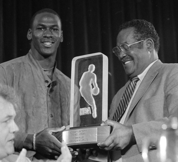 Michael Jordan, left, receives the NBA's Rookie of the Year trophy from an unidentified NBA official during NBA's award ceremony in San Francisco on June 24, 1985. (Paul Sakuma/AP)