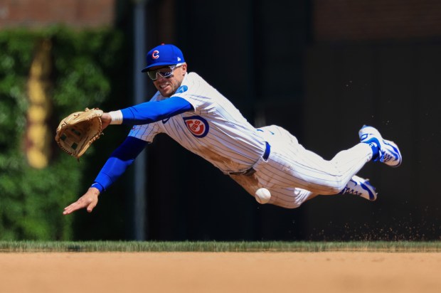 Cubs second baseman Nico Hoerner dives for a single hit by Reds center fielder TJ Friedl in the sixth inning May 31, 2025, at Wrigley Field. (John J. Kim/Chicago Tribune)