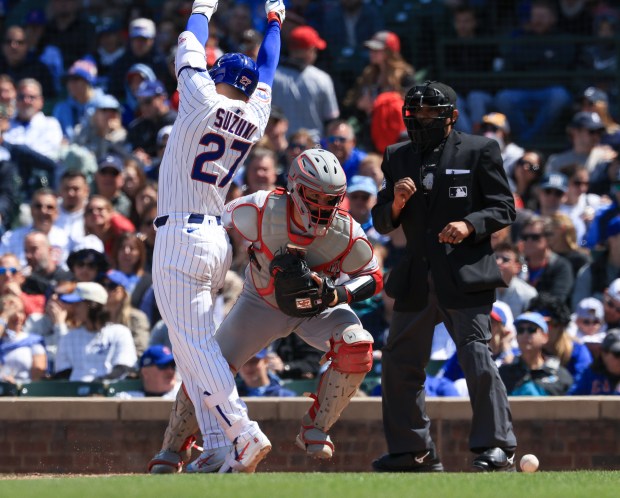 Cubs designated hitter Seiya Suzuki scoots out of the way as Reds catcher José Trevino chases the ball in the sixth inning May 31, 2025, at Wrigley Field. (John J. Kim/Chicago Tribune)