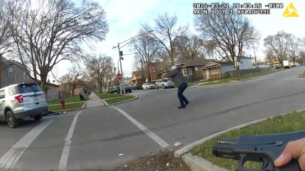 A still image of a video released by the Civilian Office of Police Accountability shows a group of Chicago police officers surrounding a vehicle driven by Dexter Reed, 26, after an "exchange of gunfire" in which Reed was fatally shot on March 21, 2024 in the Humboldt Park neighborhood. (Chicago Police Department)