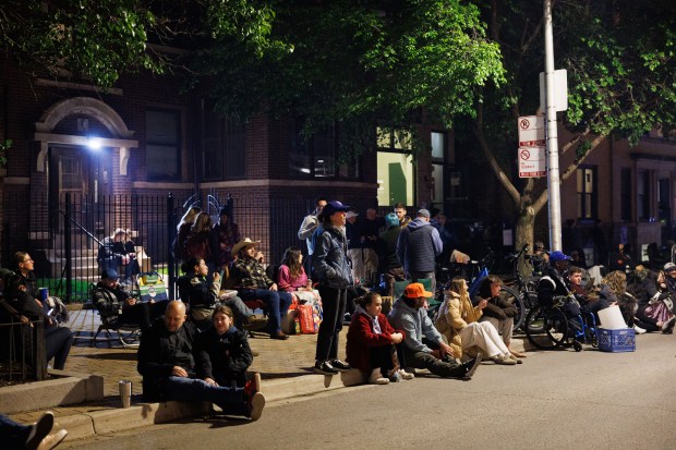 Fans stand outside Wrigley Field while Post Malone performs, May 22, 2025, in Chicago. The concert is Malone's first performance at Wrigley Field. (Armando L. Sanchez/Chicago Tribune)