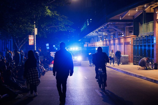 Fans stand outside Wrigley Field while Post Malone performs, May 22, 2025, in Chicago. The concert is Malone's first performance at Wrigley Field. (Armando L. Sanchez/Chicago Tribune)