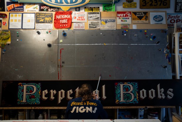 Andrew McClellan, of Heart & Bone Sign, outlines a sign for a client, in the Heart & Bone Sign studio. (E. Jason Wambsgans/Chicago Tribune)