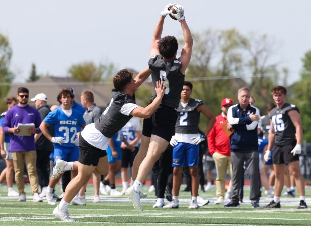 St. Charles North football players Wyatt Brandt, left, and Braden Harms perform receiving drills as college coaches watch during the team's showcase day May 7, 2025, in St. Charles. (John J. Kim/Chicago Tribune)
