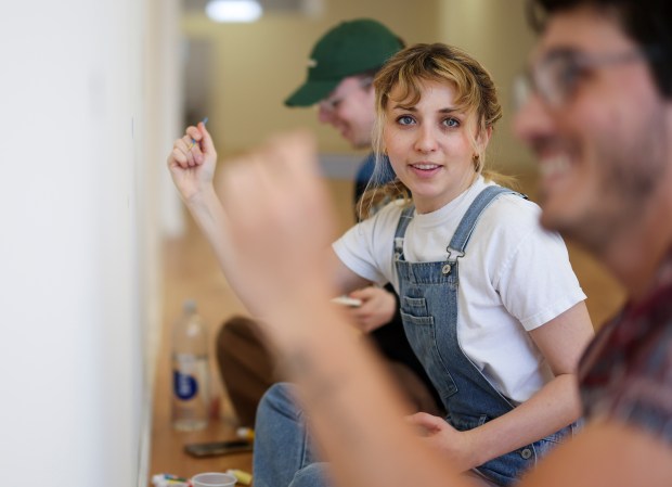 Kat Abughazaleh, who has announced a campaign for Illinois' 9th Congressional District, chats with Jacob Geittmann, a resident of Buena Park, as they paint a wall in her brand-new campaign office in Rogers Park on May 6, 2025. Abughazaleh invited people to stop by the new office to paint the walls and learn more about her campaign. (Eileen T. Meslar/Chicago Tribune)