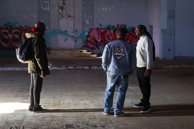 Joe Hall of JBlendz Holdings right, speaks to Melvin Griggs, left, and Ronald Cashaw, inside the former St. Mary of the Assumption Church on May 8, 2025. Hall, whose company owns the building, opened it for people to go inside. (Eileen T. Meslar/Chicago Tribune)