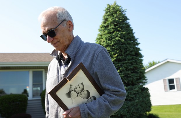 John Prevost, brother of new Pope Leo XIV, holds a portrait of the three Prevost brothers from 1958 while answering reporters' questions outside his home on May 8, 2025, in New Lenox. (John J. Kim/Chicago Tribune)