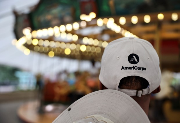 Chicago HOPES for Kids program director Dajuan King wears a hat adorned with the AmeriCorps logo as he watches guests ride the carousel during an after-hours field trip to the Lincoln Park Zoo on May 15, 2025. (Chris Sweda/Chicago Tribune)