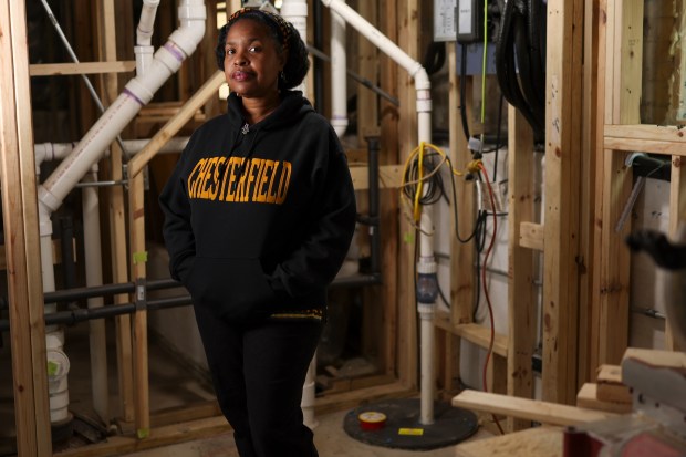 Lori Burns stands near her sump pump, which was installed in 2022, in the basement of her home in Chatham on April 23, 2025. Burns has installed multiple flooding solutions including a rain garden and sump pump. (Eileen T. Meslar/Chicago Tribune)