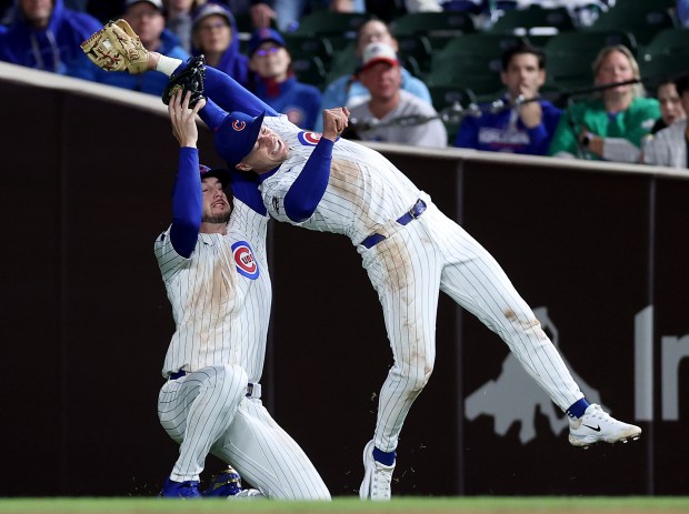 Chicago Cubs second baseman Nico Hoerner (right) collides with outfielder Kyle Tucker after Hoerner made a catch of a short fly ball in the seventh inning of a game against the Colorado Rockies at Wrigley Field in Chicago on May 27, 2025. (Chris Sweda/Chicago Tribune)