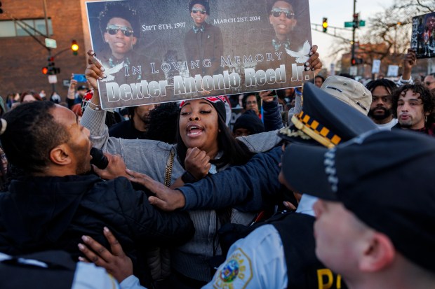 Holding a sign of her brother, Porscha Banks, a sister of Dexter Reed, argues with officers while attending a rally at CPD's Harrison District (11th) after the Civilian Office of Police Accountability released body camera video of the fatal shooting of Dexter Reed, 26, who was killed on March 21, in an "exchange of gunfire" with officers April 9, 2024. (Armando L. Sanchez/Chicago Tribune)