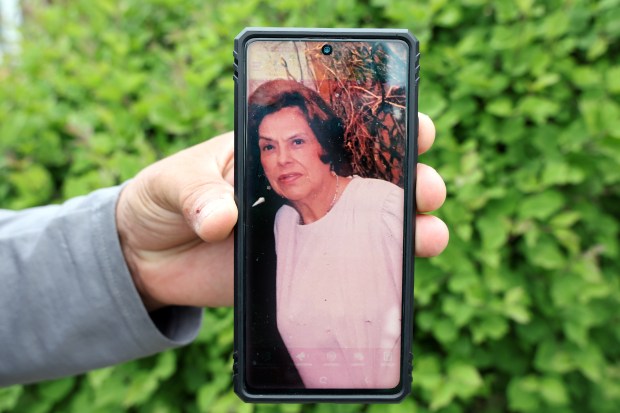 Fernando Ochoa displays a photo of his mother, Maria Ochoa, on May 27, 2025, days after she was struck and killed while walking by a car involved in a collision at Archer and Laramie avenues in Chicago. (Terrence Antonio James/Chicago Tribune)