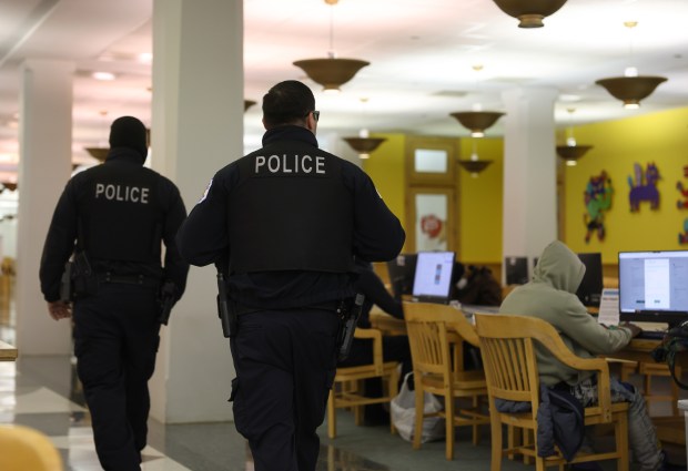 A pair of police officers make a brief walk-through of the computer commons area at the Harold Washington Library Center on April 8, 2025. (John J. Kim/Chicago Tribune)