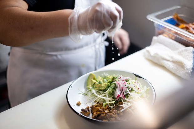 Olga Llinin squeezes fresh lime for the Antique Taco Salad at Antique Taco in Chicago on April 30, 2025. (Audrey Richardson/Chicago Tribune)