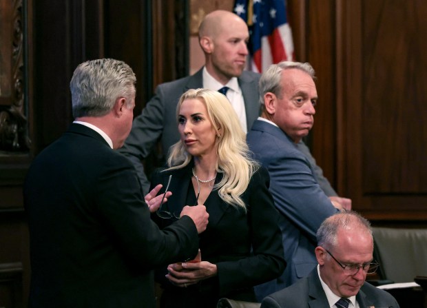 Members of the Senate Transportation Committee, including state Sen. Darby Hills, center, talk before meeting on the Northern Illinois Transit Authority Act, House Bill 3438, which would replace the Regional Transportation Authority, at the state Capitol on May 29, 2025, in Springfield. (John J. Kim/Chicago Tribune)