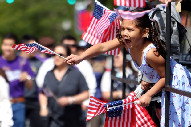 Children wave flags at the McKinley Park Memorial Day parade, May 26, 2025. (Antonio Perez/Chicago Tribune)