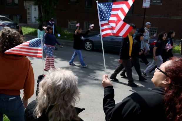 People wave flags at the McKinley Park Memorial Day parade, May 26, 2025. (Antonio Perez/Chicago Tribune)