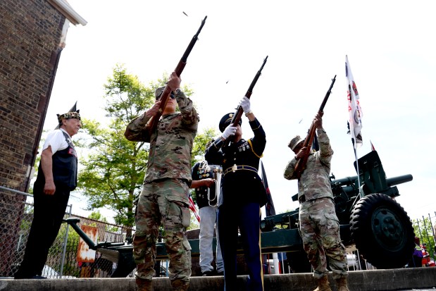 Honor guard members perform a ceremonial rifle salute of 9 volleys during McKinley Park's Memorial Day service following a parade, May 26, 2025. (Antonio Perez/Chicago Tribune)