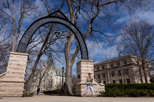 People walk by the school arch on the Northwestern University campus on March 31, 2025, in Evanston. (Brian Cassella/Chicago Tribune)