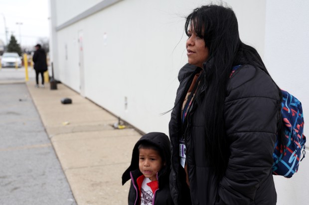 Venezuelan migrants Maria Munoz, 39, and her son Nicolas, 5, stand outside a combined shelter, used to house migrants and homeless on April 10, 2025. (Antonio Perez/Chicago Tribune)