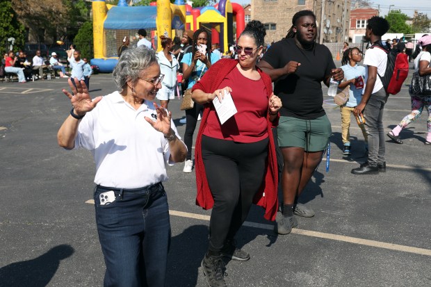 Jacinta Warnie, second from left, who works part-time at Saint Sabina Church in Chicago, dances to music during a celebration of the 50th anniversary of the ordination of Rev. Michael Pfleger on May 14, 2505. (Terrence Antonio James/Chicago Tribune)