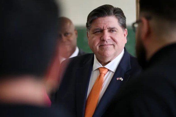 El gobernador J. B. Pritzker escucha a Chris Martínez, instructor de la Escuela de Oficios RR, hablar sobre sus programas y estudiantes antes de una conferencia de prensa en la escuela en Melrose Park el 14 de abril de 2025. (Eileen T. Meslar/Chicago Tribune)