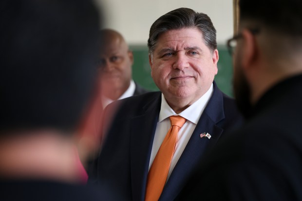 Gov. JB Pritzker listens to RR Trade School instructor Chris Martinez talk about its programs and students before a news conference at RR Trade School in Melrose Park on April 14, 2025. (Eileen T. Meslar/Chicago Tribune)