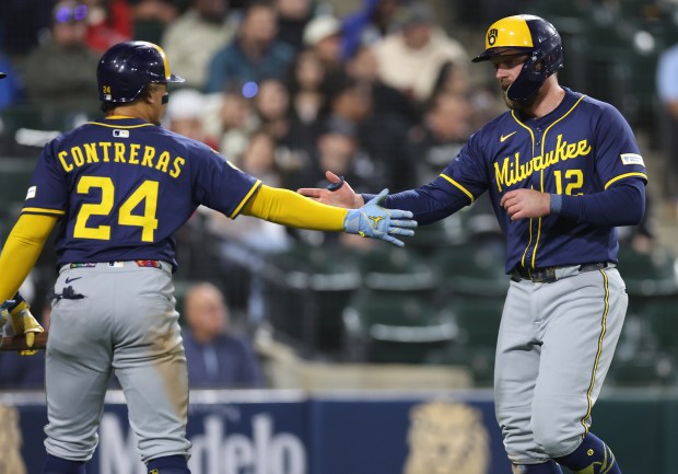 Milwaukee Brewers catcher William Contreras (24) and first baseman Rhys Hoskins (12) celebrate after both scored on a single by teammate Caleb Durbin in the sixth inning of a game against the Chicago White Sox at Rate Field on April 29, 2025. (Chris Sweda/Chicago Tribune)