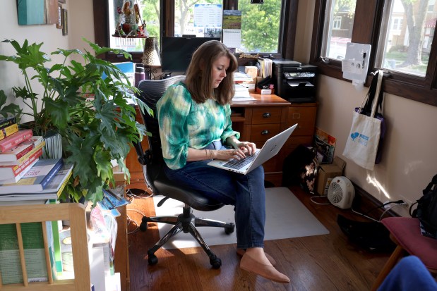 Therapist Jennifer Froemel works on her laptop at her home office in Brookfield on May 12, 2025. Lawmakers are considering a bill to tackle the problem of why many therapists don't take private insurance. The bill would raise reimbursement rates for therapists from private insurers. (Antonio Perez/Chicago Tribune)