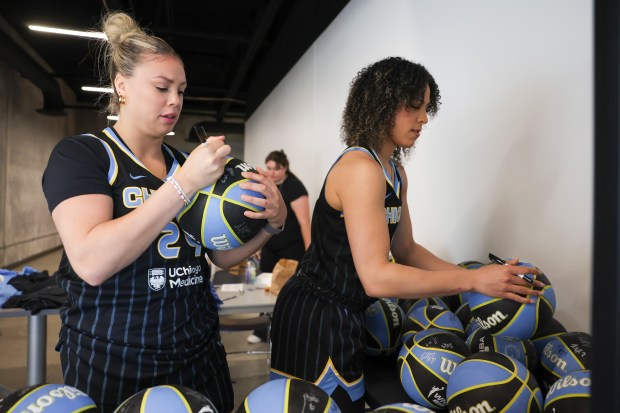 Sky guard Rachel Banham, left, and guard Kia Nurse autograph basketballs at media day Monday, May 12, 2025. (Eileen T. Meslar/Chicago Tribune)