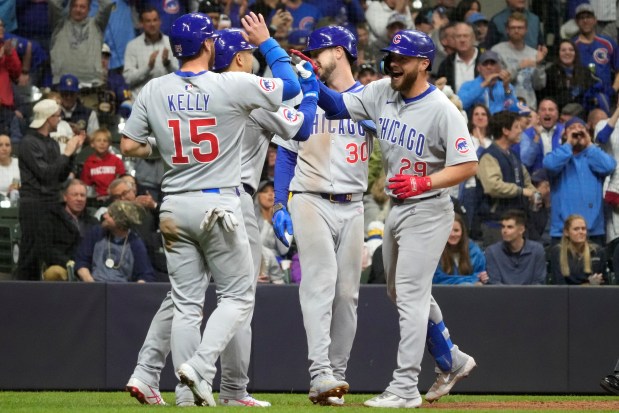 Cubs first baseman Michael Busch (29) high-fives Carson Kelly (15) after hitting a grand slam during the second inning against the Brewers on May 2, 2025, in Milwaukee. (Kayla Wolf/AP)