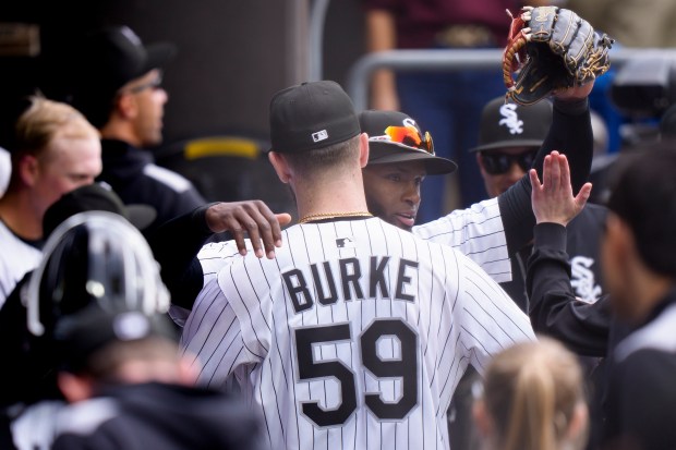White Sox starter Sean Burke hugs Luis Robert Jr. after the center fielder robbed the Brewers' Rhys Hoskins of a grand slam in the first inning on May 1, 2025, at Rate Field. (Matt Dirksen/Getty Images)