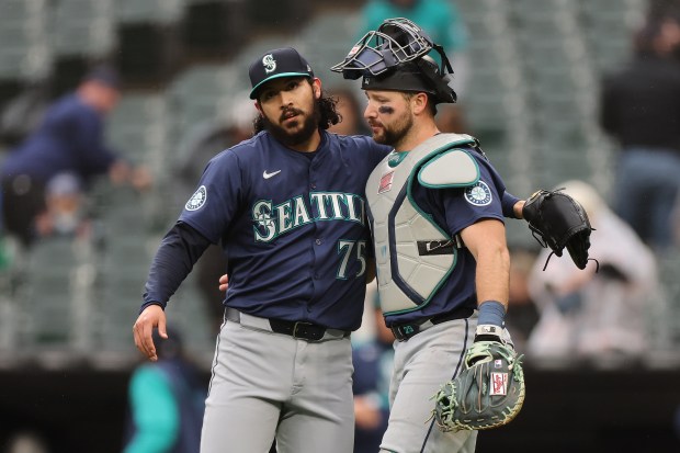 Mariners closer Andrés Muñoz, left, and catcher Cal Raleigh celebrate the final out after defeating the White Sox 6-5 on May 21, 2025, at Rate Field. (Michael Reaves/Getty Images)