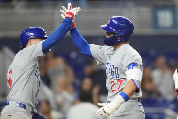 Chicago Cubs' Seiya Suzuki (27) is met by Matt Shaw, left, after hitting a two-run home run during the sixth inning of a baseball game against the Miami Marlins Tuesday, May 20, 2025, in Miami. (AP Photo/Lynne Sladky)