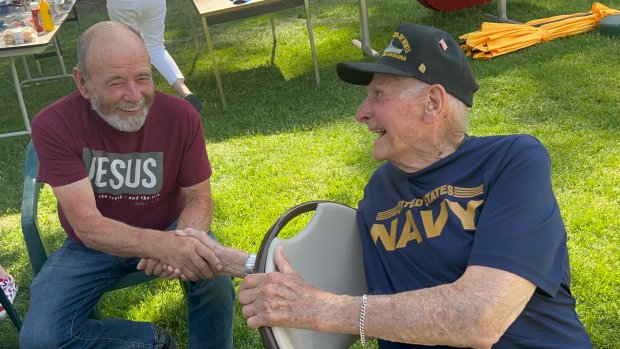 Vietnam veteran Ed Huss, left, and World War II veteran Dick Miller shake hands during a Memorial Day picnic hosted by Huss on his property on Hankes Road in Aurora.