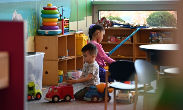 In a play area, one toy stands out as a blue Star Wars lightsaber, held by (in pink) Valentina Serrato, 5, of Zion. Playing with the red truck is Jonathan Alvarez, 2, of Zion at Star Wars Day on May 3, 2025 at the Zion-Benton Public Library District in Zion. (Karie Angell Luc/Lake County News-Sun)