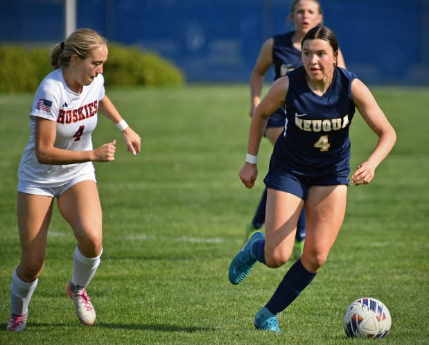 Neuqua Valley's Allessandra Russo looks to pass the ball as Naperville North's Lily Radek defends