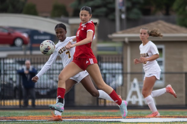 Neuqua Valley's Asha Kikama competes for the ball with Naperville Central's Paige Connelly