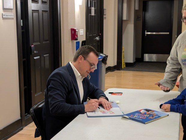 Chasten Buttigieg signs a copy of his new book, "Papa's Coming Home," at North Central College's Meiley-Swallow Hall in Naperville on Thursday, May 22, 2025. (Tess Kenny/Naperville Sun)