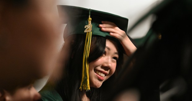 Ruina Liu of Vernon Hills adjusts the mortarboard cap behind the scenes before commencement for Adlai E. Stevenson High School graduation at NOW Arena in Hoffman Estates on May 23, 2025. (Karie Angell Luc/Pioneer Press)