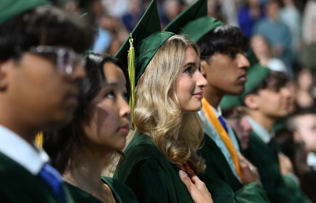 Third from left, during the national anthem is Anastasia Berestova of Vernon Hills at the Adlai E. Stevenson High School commencement at NOW Arena in Hoffman Estates on May 23, 2025. (Karie Angell Luc/Pioneer Press)