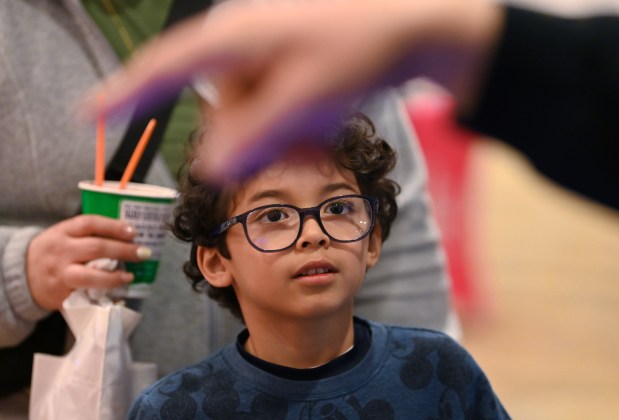 Damian Mena, 6, a kindergartner from Vernon Hills, stops at a community table in the company of his mother Martha Mena at the GLMV Extreme Block Party Family Expo and Taste of the Towns on May 3, 2025 in Mundelein at the DoubleTree by Hilton Hotel Mundelein. (Karie Angell Luc/Pioneer Press)