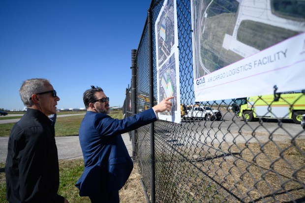 Matt Saltanovitz, with the Indiana Economic Development Corporation, on right, points out features on renderings of an approximately $24 million infrastructure enhancement plan at the Gary/Chicago International Airport before a groundbreaking ceremony for the project on Tuesday, Oct. 8, 2024. (Kyle Telechan/for the Post-Tribune)