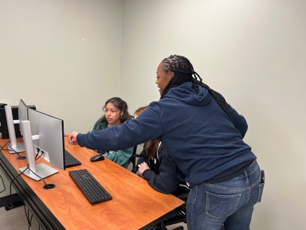 Kourtney Trotter, an operation specialist, helps two high school girls with a simulation on Friday during BP's Girls in STEM event. Participants took part in activities related to BP and STEM jobs. (Maya Wilkins/Post-Tribune)