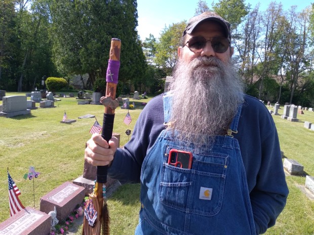Tony Reales holds his homemade walking stick which he brought with him for the Memorial Day ceremony Monday, May 26, 2025, at St. Patrick's Cemetery in Chesterton, which preceded the main ceremony at Chesterton Cemetery. (Jim Woods/for Post-Tribune)