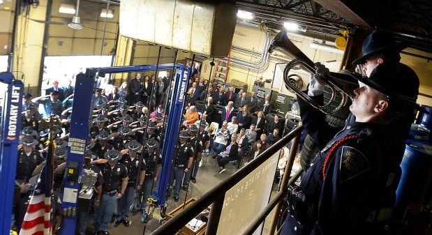 Indiana State Police Officer Lecil Martin (left) plays taps and Indiana State Police Officer Corey Adam salutes during the annual memorial service for officers killed in the line of duty at the Indiana State Police post in Lowell on May 20, 2025. (John Smierciak / for the Post-Tribune)