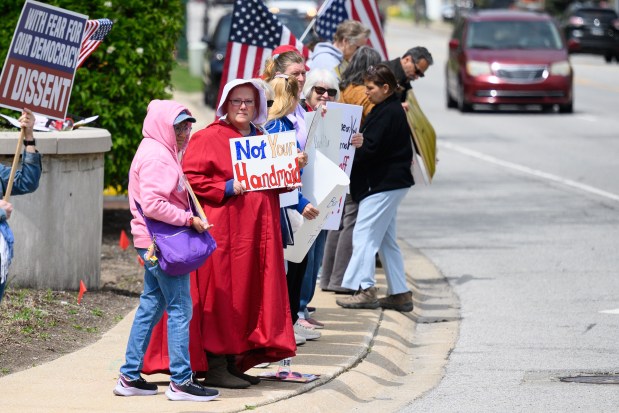 Protesters line the street outside of a Munster Chamber of Commerce meeting featuring Indiana Governor Mike Braun as speaker on Thursday, May 8, 2025. (Kyle Telechan/for the Post-Tribune)