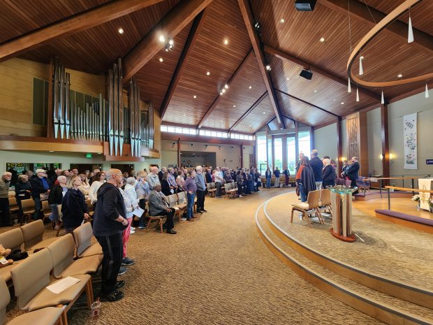 People stand at the Porter County Housing Assembly at Christ Lutheran Church Saturday, May 3, 2025, to show support for zoning changes to Valparaiso city code that would support more affordable housing. (Shelley Jones/for Post-Tribune)