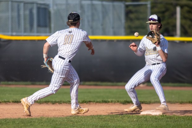 Oak Forest's Bryce Hoffman (10) tosses the ball to Blake Morin to start a double play against Lemont during a South Suburban Blue Conference game in Oak Forest on Monday, May 12, 2025. (Troy Stolt for the Daily Southtown)